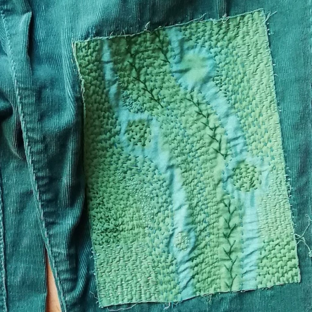 Discover Inspiring Ideas for Mending with Shibori Patterns 8 shows a hand embroidered green patch of shibori fabric