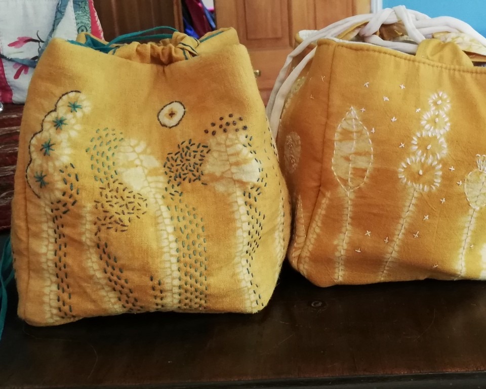 Two gold coloured embroidered shibori patterned rice pouches