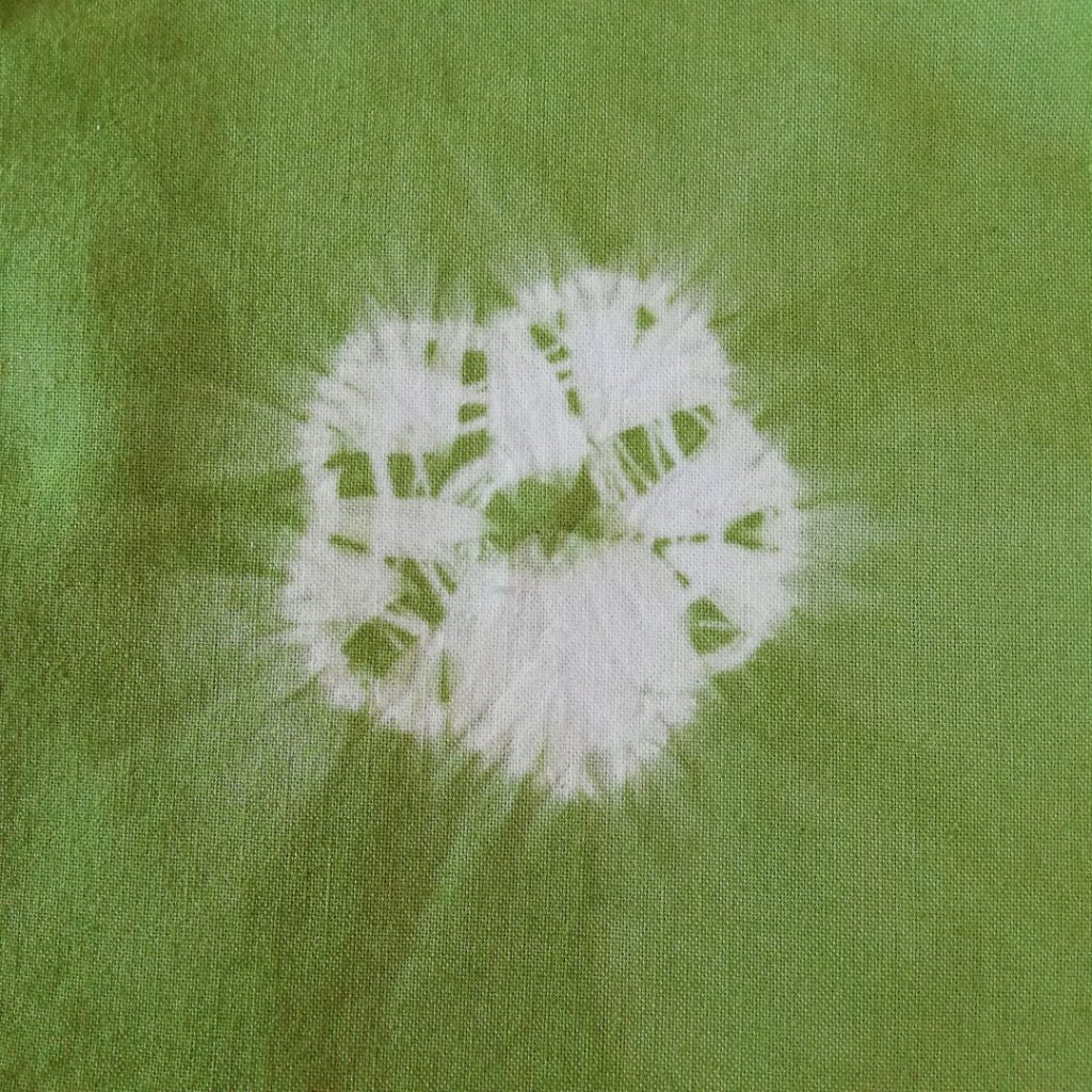 Discover Inspiring Ideas for Mending with Shibori Patterns 2 white 5 petalled flower on green fabric