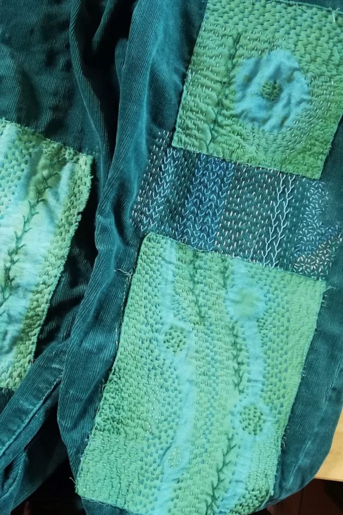 Discover Inspiring Ideas for Mending with Shibori Patterns 11 shows dark green jeans with additional embroidered mending